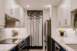 Modern kitchen with white cabinets and decor.